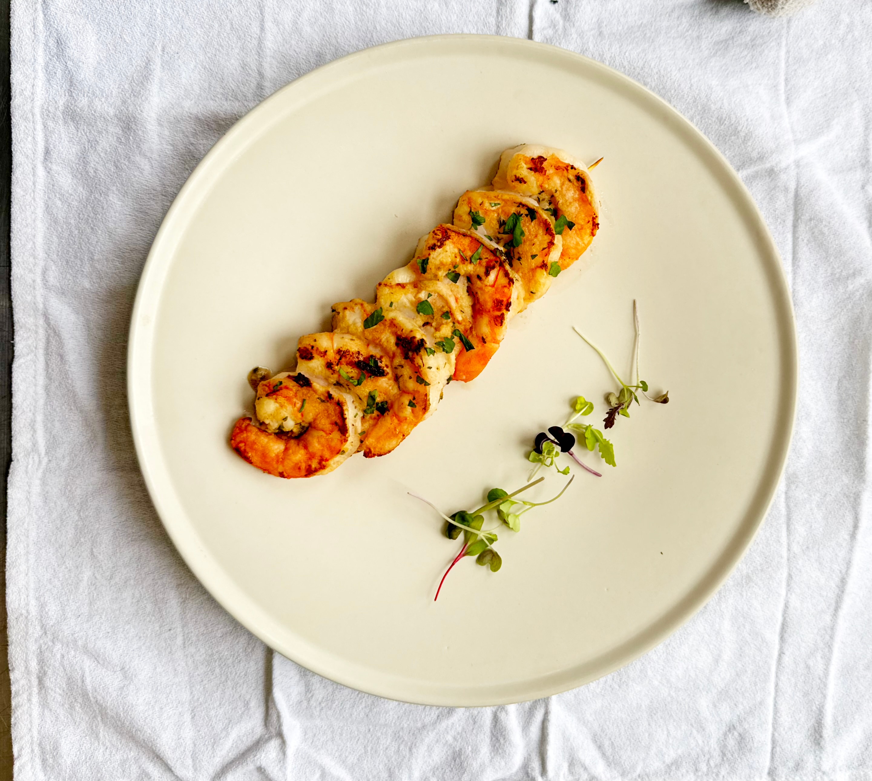 Grilled shrimp skewer with microgreens